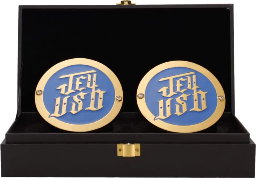 Display-grade side plate set with die-struck metal plates on a full-grain leather strap.